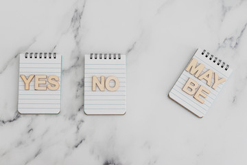 making a choice and facing doubts, notepads with Yes No and Maybe options
