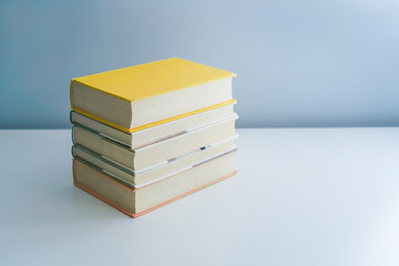 Stack of neat books on white desktop