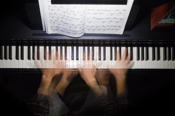 Hands playing the piano multiple exposure