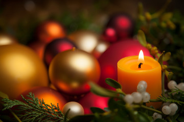 Fototapeta na wymiar Close-Up Of Illuminated Candle With Christmas Ornaments