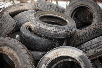 Rubber tires in a landfill. Old wheels from cars. Recycling rubber. Garbage dump with damaged wheels. Environmental pollution. A lot of waste. Tires with protectors.