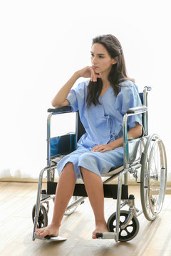 Sick girl sitting in wheelchair in the hospital room. Disabled woman suffering emotional pain patient looking desperate. Paralysis loss teenager Victims of a car accident. Disabled people concept.