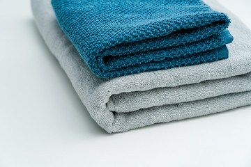 Two lovers towels and bath towels on a white table. Blue towels gray towels bath towels