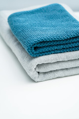 Two lovers towels and bath towels on a white table. Blue towels gray towels bath towels