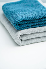 Two lovers towels and bath towels on a white table. Blue towels gray towels bath towels