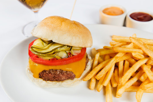 Cheeseburger with cheddar cheese, tomato, pickles and fries