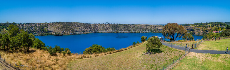 Fototapeta na wymiar Tourists on viewing platform at the Blue Lake in Mount Gambier, South Australia - wide aerial panorama