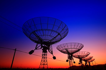 The silhouette of a radio telescope observatory