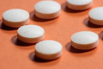 Pills on an orange background is macro, soft focus