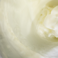 Splashes of liquid milk on a square abstract background is macro