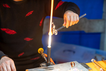 Fototapeta premium A craftsman who is making glass crafts out of flame