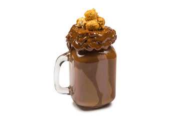 Chocolate milkshake with whipped cream, cookies, waffles, served in glass mason jar. 