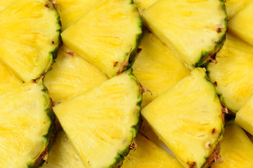 Pineapple juicy yellow slices background. Top view.