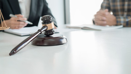 Judge gavel with Justice lawyers having team meeting at law firm background. Concepts of Law and Legal services.