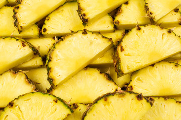 Pineapple juicy yellow slices background. Top view.