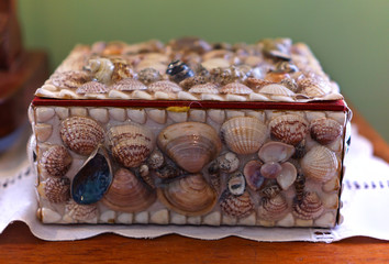 Box decorated with shells on wooden table