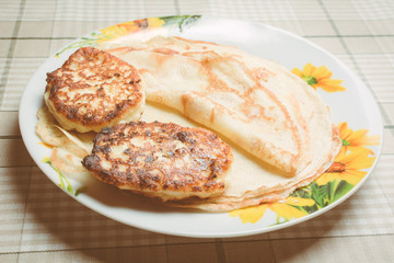 Fried curd cheese cakes on pancakes in plate.