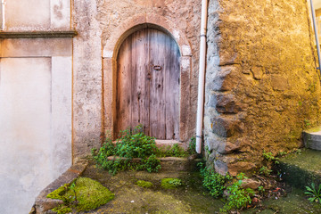 Fototapeta na wymiar Italy, Sicily, Province of Messina, Novara di Sicilia. A weathered arched door in the medieval hill town of Francavilla di Sicilia.