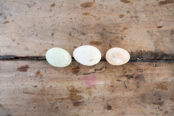 Duck eggs are arranged on a farmer's wooden board.