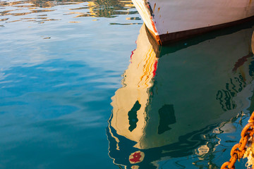Italy, Sicily, Agrigento Province, Sciacca..reflection of a fishing boat in the harbor of Sciacca, on the Mediterranean Sea. - obrazy, fototapety, plakaty