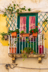 Fototapeta na wymiar Italy, Sicily, Trapani Province, Trapani. Balcony with flowers in pots in the village of Trapani.