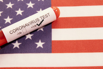 Coronavirus positive test on blood collection tubes on US flag - concept of virus found in USA.