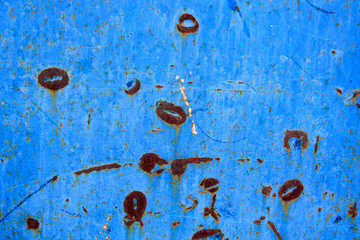 Abstract background of peeling white paint on a blue wall, rust on a cold wall