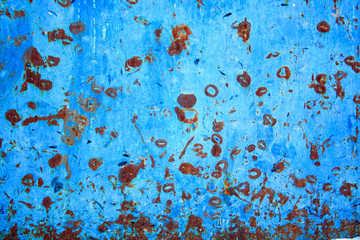 Abstract background of peeling white paint on a blue wall, rust on a cold wall