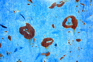 Abstract background of peeling white paint on a blue wall, rust on a cold wall