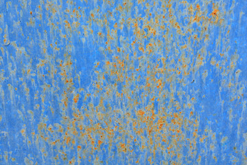 Abstract background of peeling white paint on a blue wall, rust on a cold wall