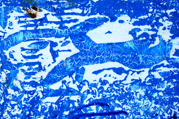 Abstract background of peeling white paint on a blue wall, rust on a cold wall