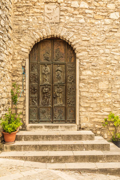 Italy, Sicily, Province of Palermo, Prizzi. Carved wooden door and a stone wall in Prizzi.