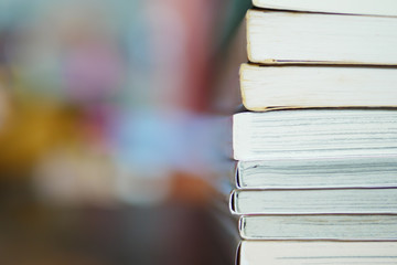 stack of paperback books with colorful background