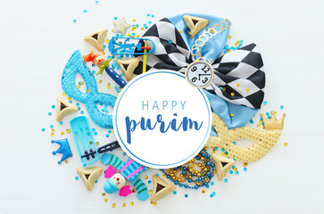 Purim celebration concept (jewish carnival holiday) over white wooden background. Top view, Flat lay