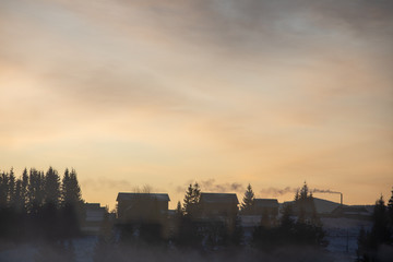 view of sunrise at mountains village. building with chimney