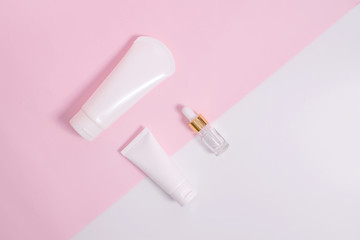 Cosmetics and serums on a white and pink background