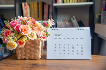 Planner and Calendar Concept.Desktop Calendar 2020,notebook and vase of rose flower placed on office desk in library.