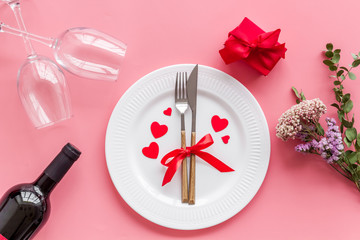 Romantic dinner on Valentines Day. Wine, plate, present box on white background top-down