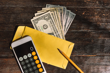 Calculator and dollar Bills on a wooden table, counting money