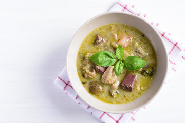 Thai green curry chicken in a bowl on white table, Thai food