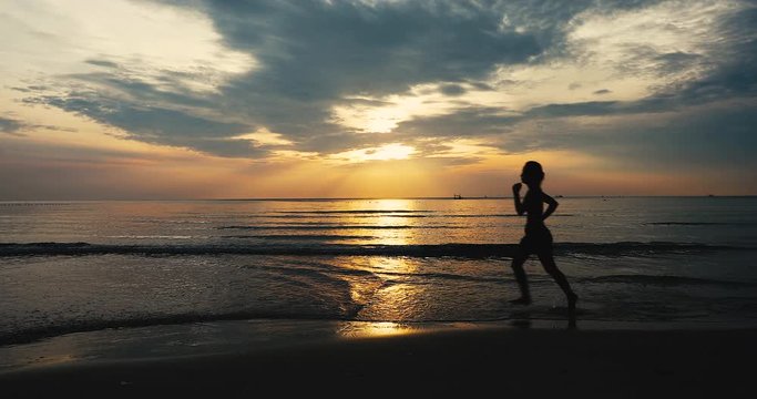 young woman athlete running on beach exercising female runner sprinting training in evening seaside background sunset