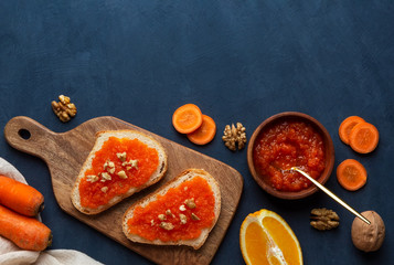 Sandwiches with carrot jam on a cutting board on a blue background