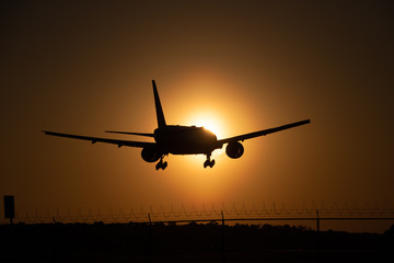 Fototapeta na wymiar airplane landing into sunset