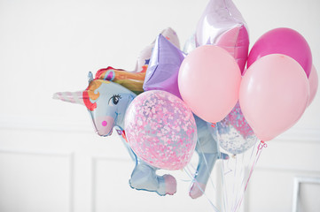 bunch of colorful balloons with a large foil ball in the shape of a unicorn
