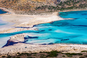 Balos lagoon on Crete island, Greece. Tourists relax and bath in crystal clear water of Balos beach. The most unique natural attraction in Crete.