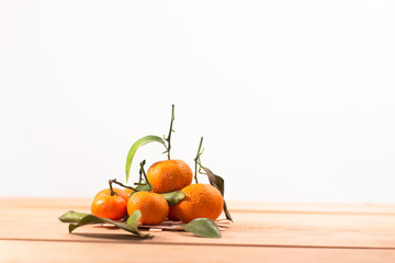 Fresh mandarin orange with leaf on wooden, white background.selective focus