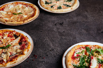 Traditional Italian pizza on a dark background top view copy space.