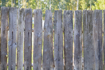 Old wooden fence in summer village in Russia