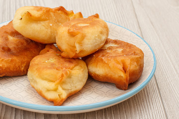 Plate with fried pies on wooden boards