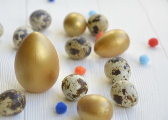 Easter.  eggs of gold and natural color on a light background.